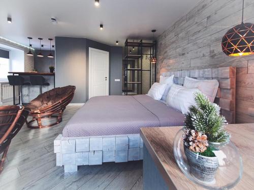 ein Schlafzimmer mit einem Kingsize-Bett und einem Tisch in der Unterkunft Ayezova 7, LOFT apartment in Öskemen