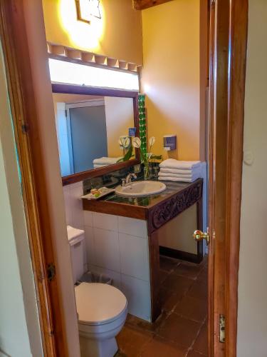 a bathroom with a sink and a toilet and a mirror at Hotel San Buenaventura de Atitlán in Panajachel