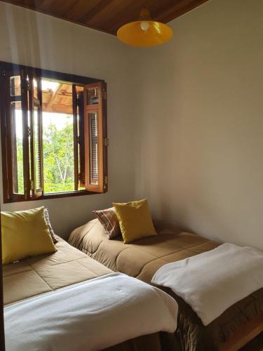 two beds in a room with a window at Reino Solar in Cunha