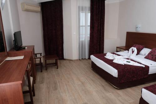 a hotel room with a bed and a television at Anitas Hotel in Konaklı