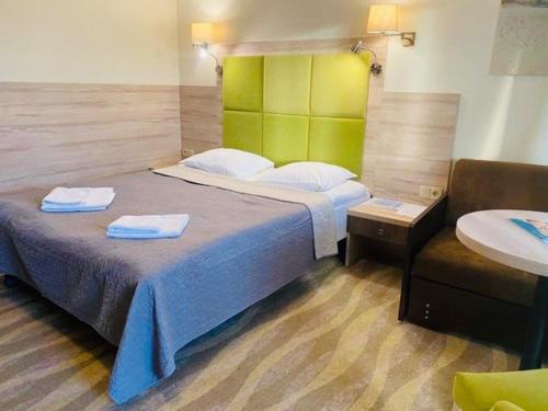 a bedroom with a bed with two towels on it at Hotel Willa Złota in Karwia