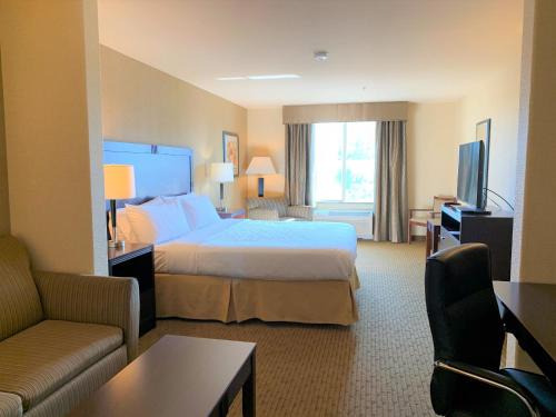 um quarto de hotel com uma cama e uma televisão em Holiday Inn Express Fresno Northwest - Herndon, an IHG Hotel em Herndon