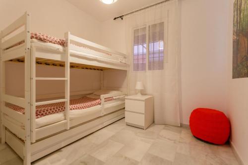 una camera con 2 letti a castello e uno sgabello rosso di BRISAS-Rota free parking by Cadiz4Rentals a Rota