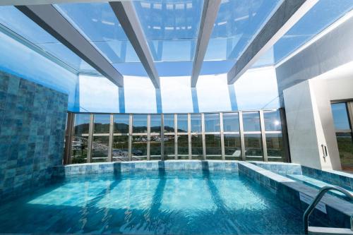 a large swimming pool in a building with a large window at Intercity Portofino Florianópolis in Florianópolis