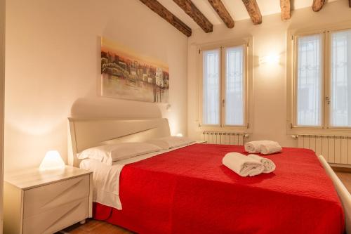 - une chambre avec un lit et une couverture rouge dans l'établissement Ca' Rella, à Venise