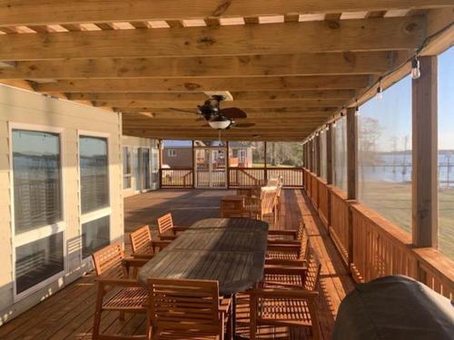 a deck with a table and chairs and a ceiling fan at Dances Bay in Elizabeth City