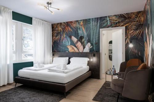 1 dormitorio con 1 cama grande y papel pintado tropical en Stay COOPER l Cà de Bezzi, en Bolzano