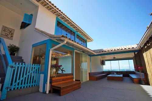 Casa con escaleras de madera y balcón con vistas al océano. en Sofia's on the Beach en Búzios