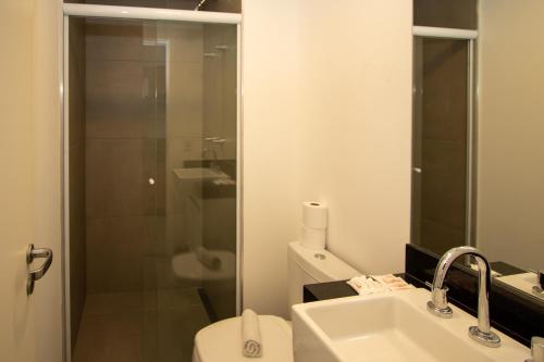 a bathroom with a toilet and a sink and a shower at VNH Residencial by Audaar in São Paulo