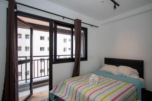 VNH Residencial by Audaar في ساو باولو: غرفة نوم بسرير ونافذة كبيرة