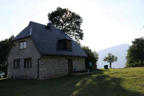 una pequeña casa de piedra en un campo de hierba en Rafting Camp Apartments Montenegro Goran Lekovic, en Žabljak