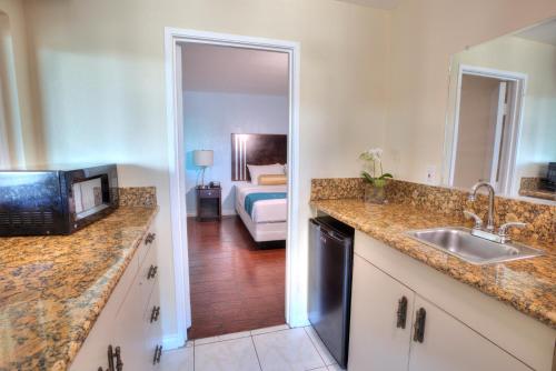 cocina con fregadero y dormitorio con cama en Sunrise Inn San Diego en San Diego