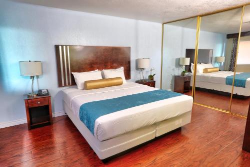 1 dormitorio con 1 cama grande y espejo en Sunrise Inn San Diego, en San Diego