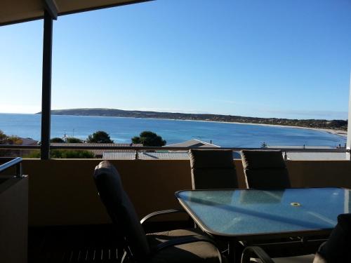 a table and chairs with a view of the ocean at Birubi Holiday Homes Kangaroo Island in Emu Bay