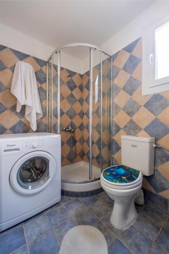 a bathroom with a washing machine and a toilet at Stone Villa Kontiani - Red Villa in Dhragoulás