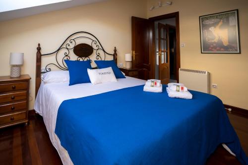 a bedroom with a blue bed with two towels on it at TuristiQA - Ático Ferrol Centro VUT-CO-02715 in Ferrol