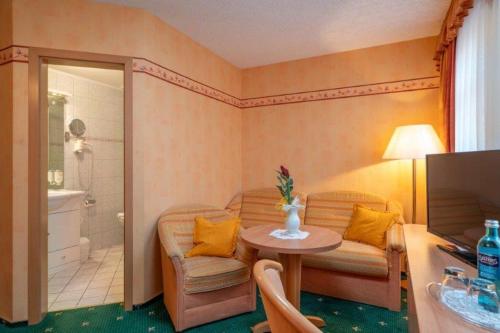 a room with a bathroom with a table and a shower at Stolberger Hof in Stolberg i. Harz