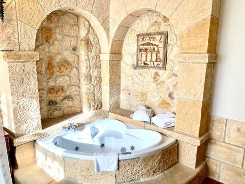 a bathroom with a tub in a stone wall at Hotel Castillo Bonavía in Pedrola