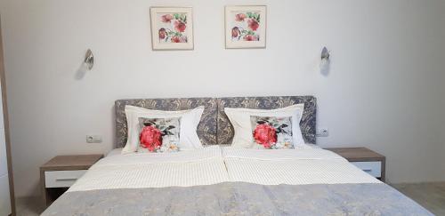 a bedroom with a bed with two pillows on it at Aparthotel Olympus Plaza - SPA & Indoor Pool in Kranevo