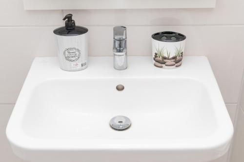 een witte wastafel met twee bakken erbovenop bij Don Vito in Belgrado