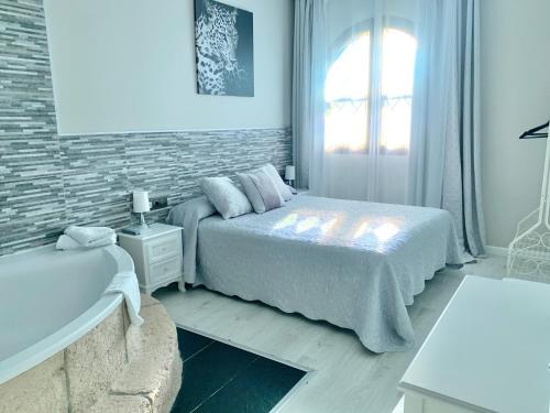 a white bedroom with a bed and a window at Hotel Castillo Bonavía in Pedrola