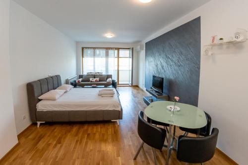 een slaapkamer met een bed, een tafel en een bank bij Don Vito in Belgrado