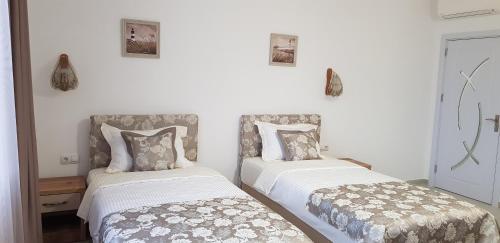 two beds sitting next to each other in a room at Aparthotel Olympus Plaza - SPA & Indoor Pool in Kranevo