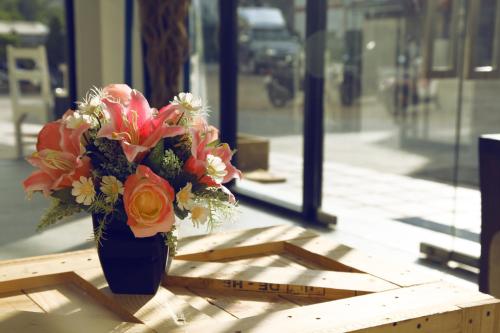 a blue vase filled with flowers sitting on a table at The Blue Pearl Kata Hotel in Kata Beach