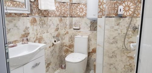 a bathroom with a toilet and a sink at Aparthotel Olympus Plaza - SPA & Indoor Pool in Kranevo