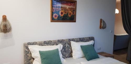 a couch with two pillows and a painting on the wall at Aparthotel Olympus Plaza - SPA & Indoor Pool in Kranevo