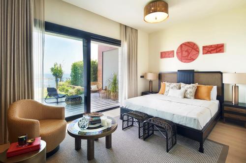 a bedroom with a bed and a living room at Root Redrock Yalıkavak in Bodrum City