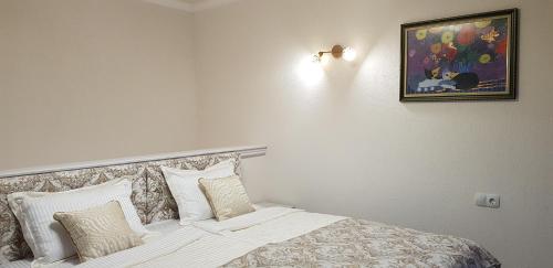 a bedroom with a bed with white sheets and pillows at Aparthotel Olympus Plaza - SPA & Indoor Pool in Kranevo