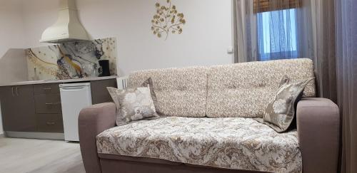 a living room with a couch with pillows on it at Aparthotel Olympus Plaza - SPA & Indoor Pool in Kranevo