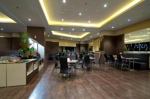 a restaurant with chairs and tables and a bar at Aria Gajayana in Malang