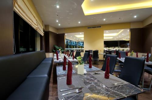 a restaurant with a long table with red napkins at Aria Gajayana in Malang