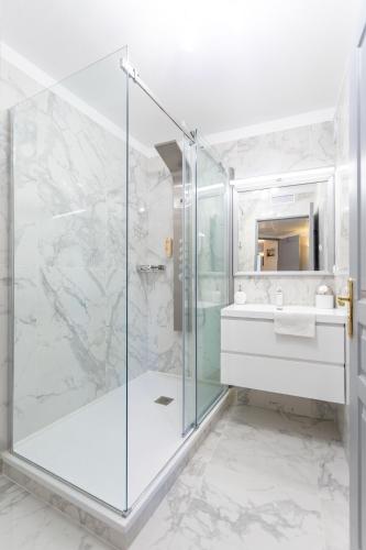une salle de bain avec une douche en verre et un lavabo dans l'établissement Appartement Standing Marseille 2 chambres 6 pers Clim Parking JO, à Marseille