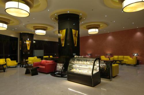 a restaurant with yellow and red chairs and tables at Aria Gajayana in Malang