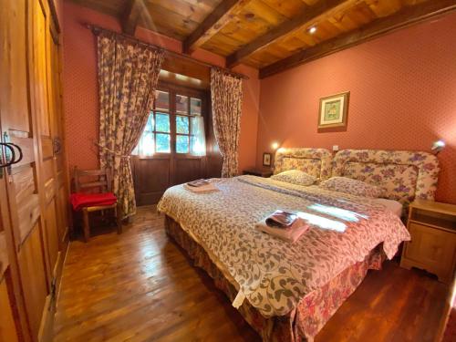 a bedroom with a large bed and a window at Pleta de Ordino 45B, Apartamento rústico para 6 personas. in Ordino