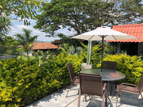 a table and chairs with an umbrella on a patio at Finca Hotel Brasilia in La Tebaida