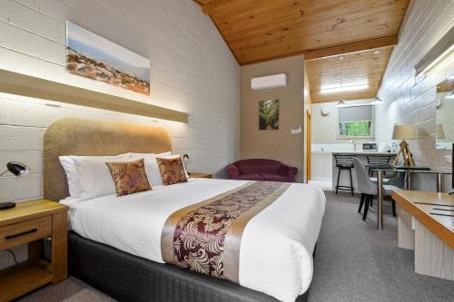 a bedroom with a large bed and a kitchen at Gold Rush Inn in Queenstown