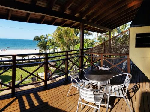 a balcony with a table and chairs and the beach at Apart Hotel Beira do Mar in Florianópolis