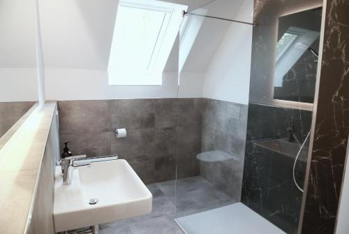 a bathroom with a sink and a shower at Helles Maisonette-Apartment am Aalener Stadtpark in Aalen