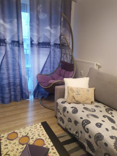 Una sala de estar con un columpio y un sofá. en Apartament Morskie Polanki, en Kołobrzeg