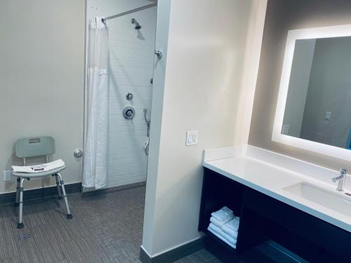 La salle de bains est pourvue d'un lavabo, d'un miroir et d'une douche. dans l'établissement Granada Inn, à Granada Hills