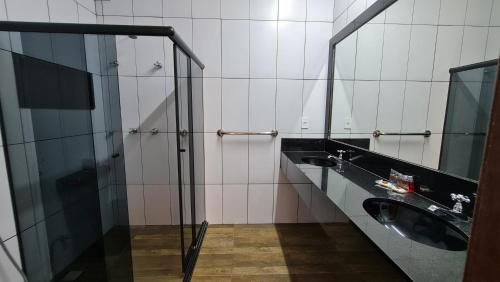 a bathroom with two sinks and a shower at Pousada Praia das Ondas - Pé na areia in Itacimirim