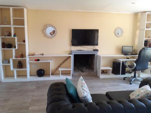 a living room with a couch and a flat screen tv at beatiful house in Vuelta de Obligado