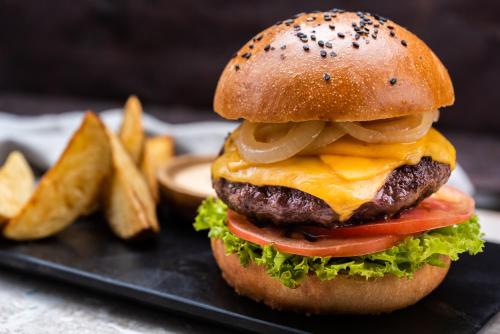 a hamburger on a plate with french fries at Oz Hotel Luxury in Cartagena de Indias