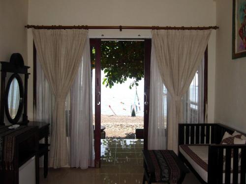 a living room with a door open to a patio at Galang Kangin Bungalows in Amed