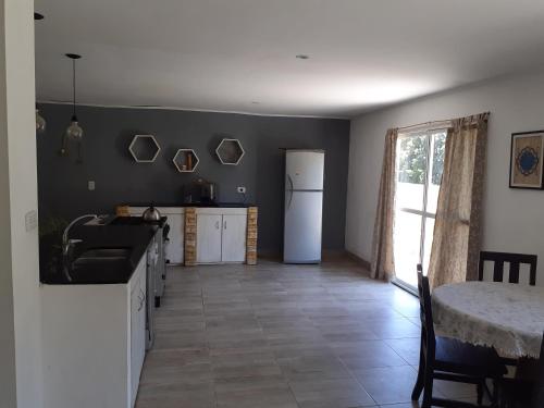 a kitchen with a white refrigerator and a table at beatiful house in Vuelta de Obligado