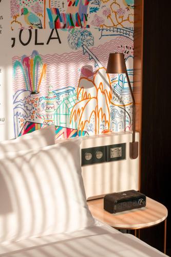 a room with a bed and a table with a lamp at Hotel Indigo Adelaide Markets by IHG in Adelaide